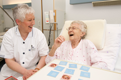 Alte Dame spielt Memory mit Pflegerin